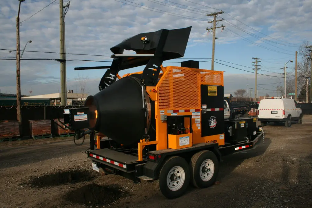 KM International's line of pavement maintenance equipment, like the KM T-2 asphalt recycler shown here, can help road maintenance crews break the pothole cycle.
