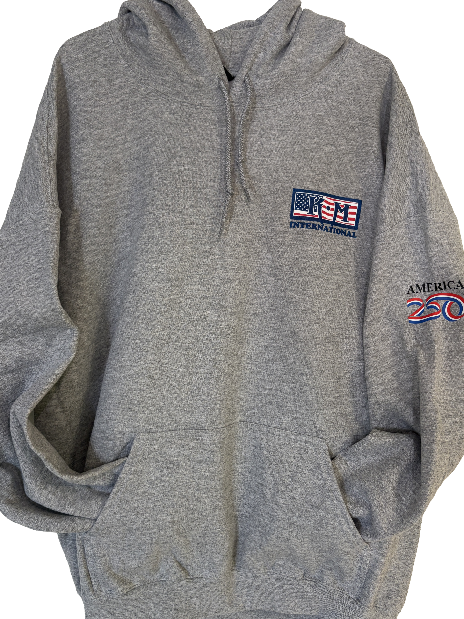 Front of the hoodie featuring the limited edition American flag themed KM International logo and the left sleeve that has an America 250 ribbon