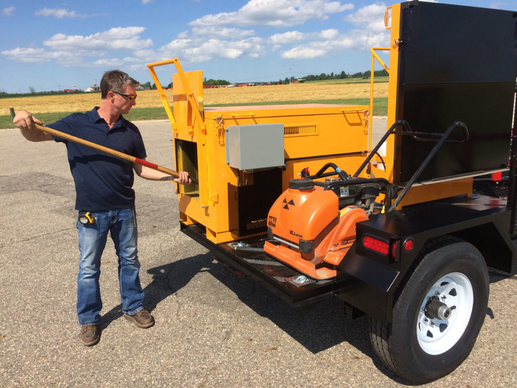 As shown here, the KM 1000 asphalt hotbox reclaimer has a single shovel port, making it ideal for smaller scale projects such as golf course pathway and park trail maintenance.