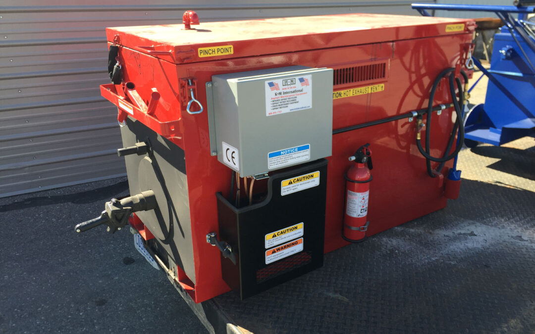 M 55 Rubber Melting Kettle on a job site, highlighting its insulated construction and easy-to-use features like the 2-inch flow valve and agitation paddle for smooth crack filling.